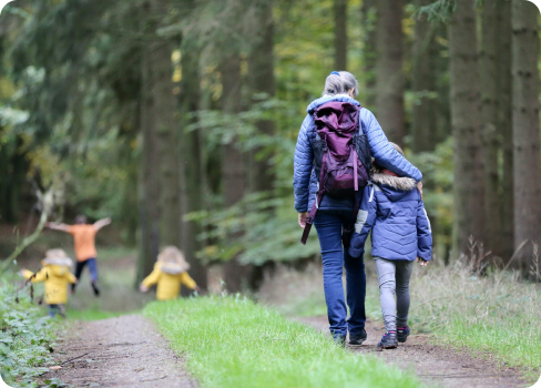 A couple of people walking in a forest.