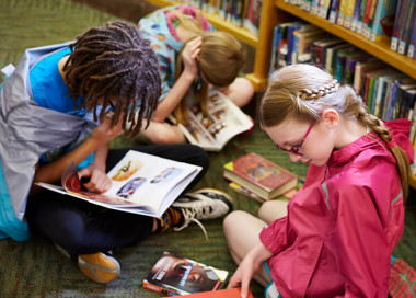 A group of children reading books.