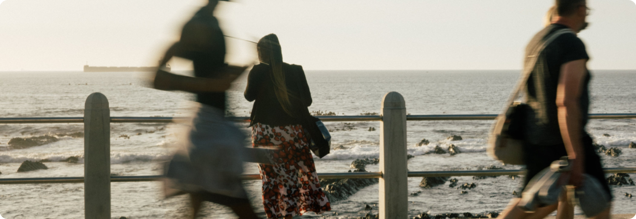 A group of people walking on a beach.
