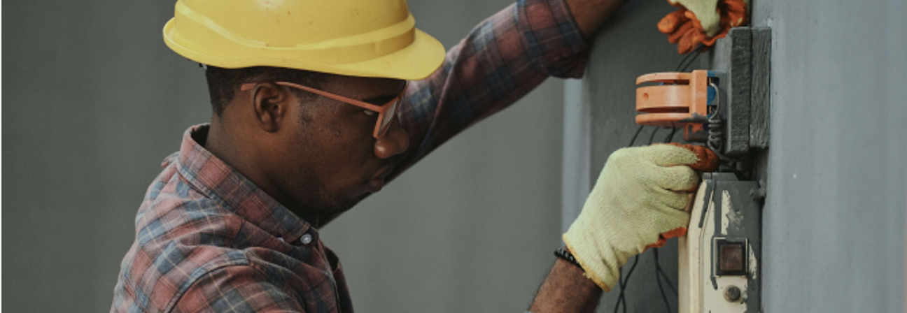 A man wearing a hard hat and holding a machine.