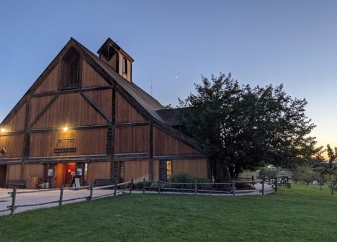A brown barn with green grass.